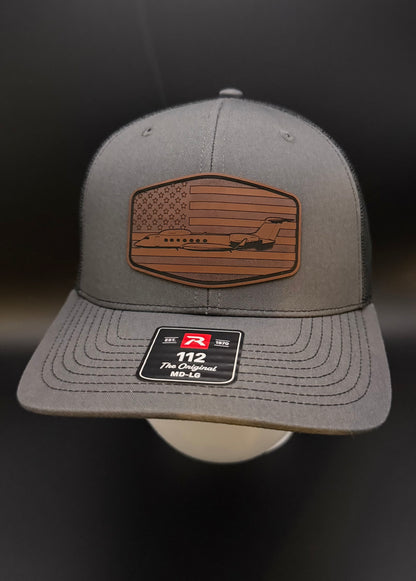 Gray cap with American flag patch and logo on a dark background