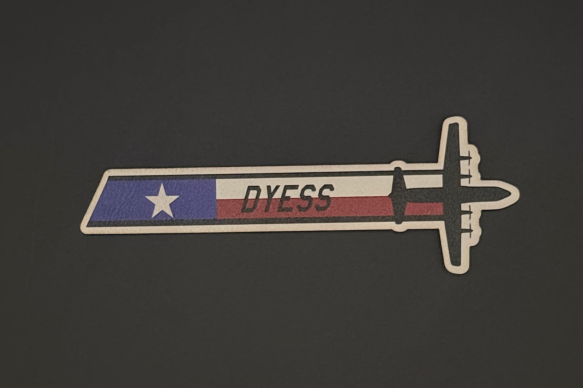 Patch with a design resembling a sword and 'DYESS' text on a dark background