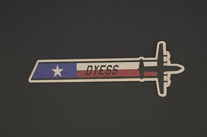 Patch with a design resembling a sword and 'DYESS' text on a dark background